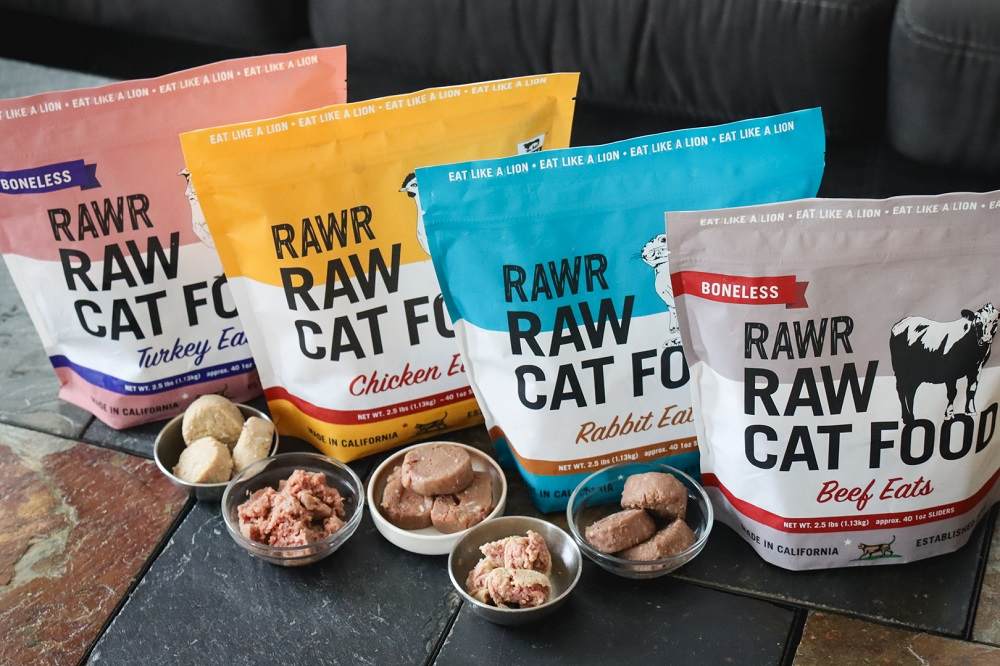 row of RAWR cat food packages with the food displayed in bowls in front